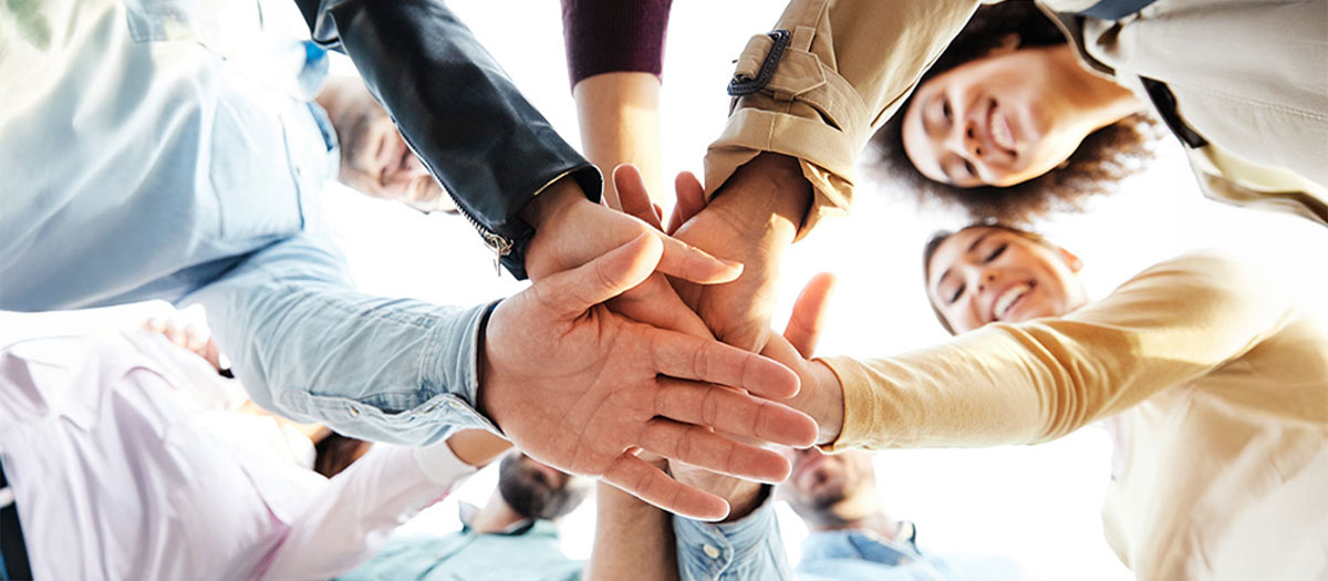 group of people holding their hands in a circle